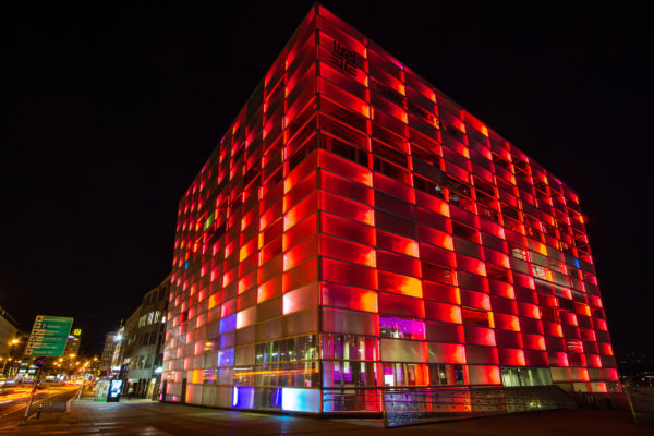 Ars Electronica Center in rotem Licht bei Nacht.